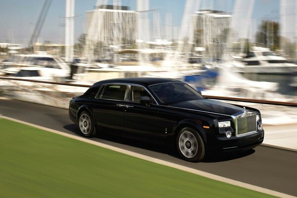 Rolls Royce negro montando en el fondo de los yates