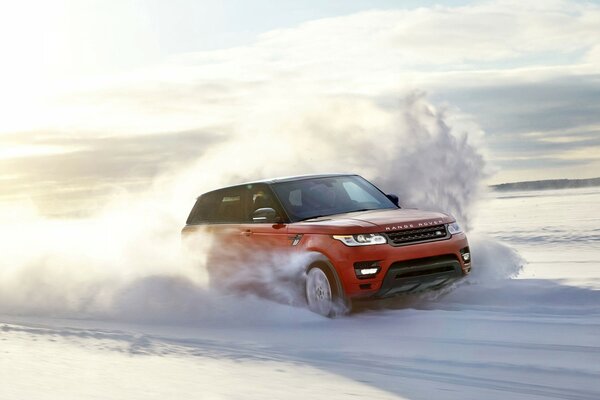 Coche rojo rápido conduce en la carretera de invierno