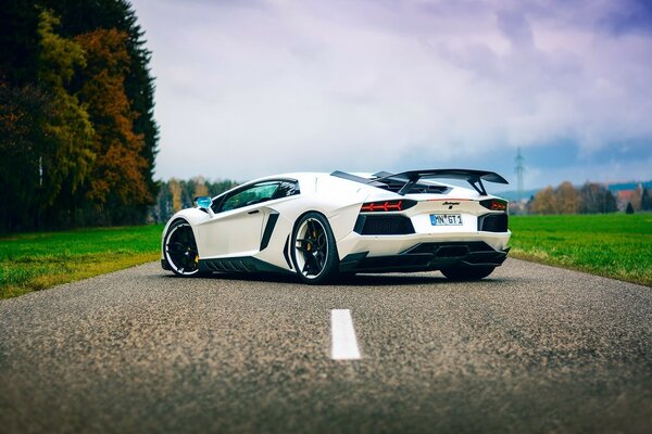 A sporty white car in the middle of the road