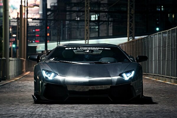 Lamborghini Aventador avec phares allumés la nuit