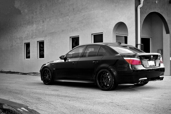 Black BMW M5 near a grey building