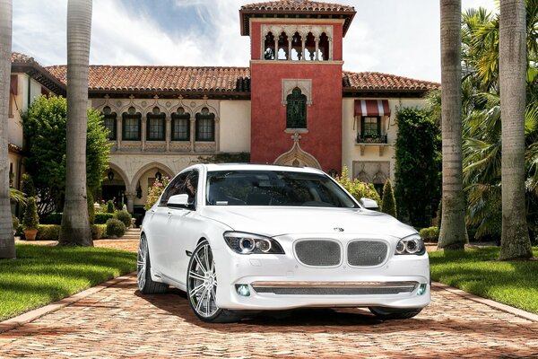 White sports bmw in the yard of a beautiful house