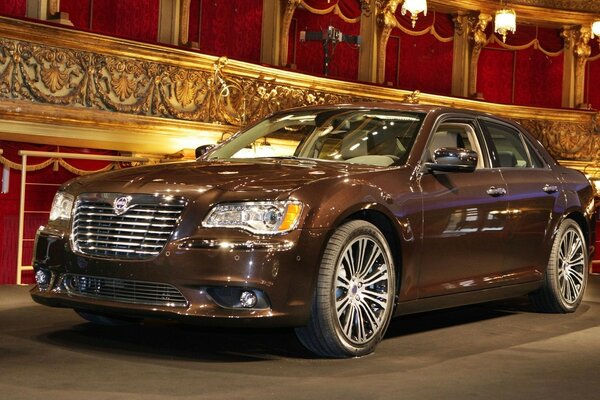 Brown lancia sedan on the background of theater curtains