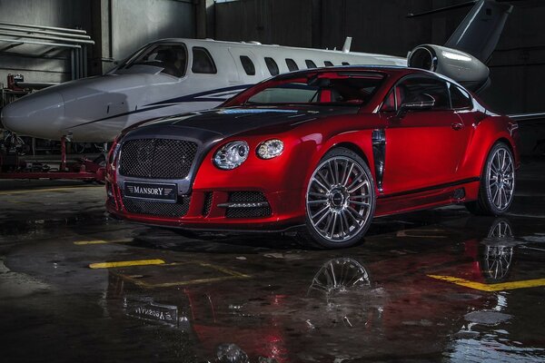 Roter Bentley mansory nahe dem Flugzeug