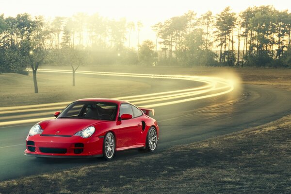 Roter Porsche auf der Straße vor Naturhintergrund