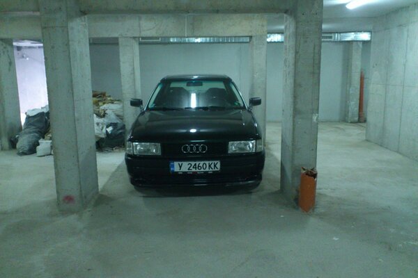 Dark Audi in a concrete garage