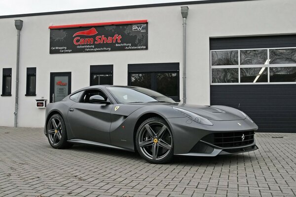 Gris ferrari F12 berlinetta sur fond de service automobile allemand