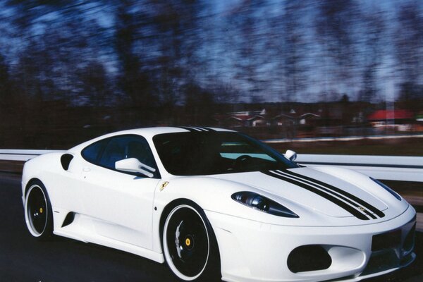 Ferrari blanco corre por la pista