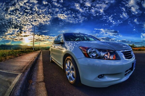 White car on the road under the sunset sky