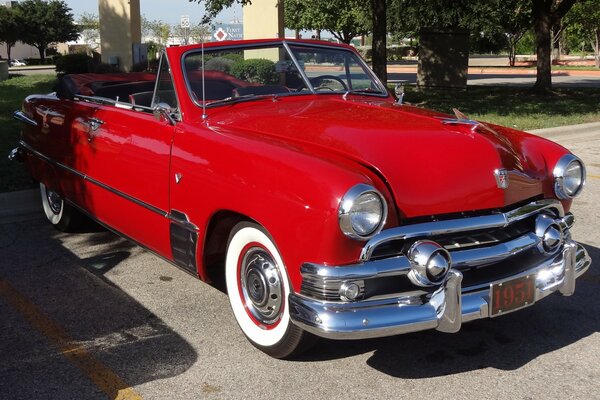 Red retro car in sunny city