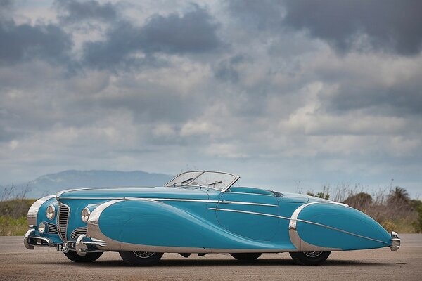 Coche retro azul en el fondo del paisaje