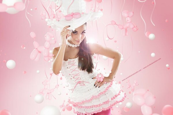 A girl in a hat and a white dress on a pink background