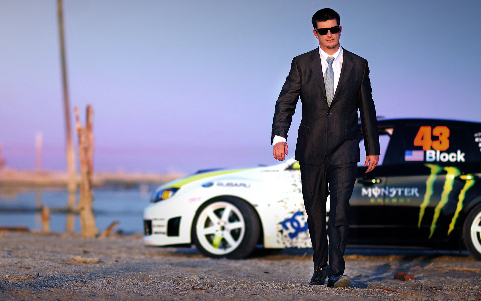 trendy guy ken block machine speed costume celebrity glasses tie jacket walking brunette sports car transport auto