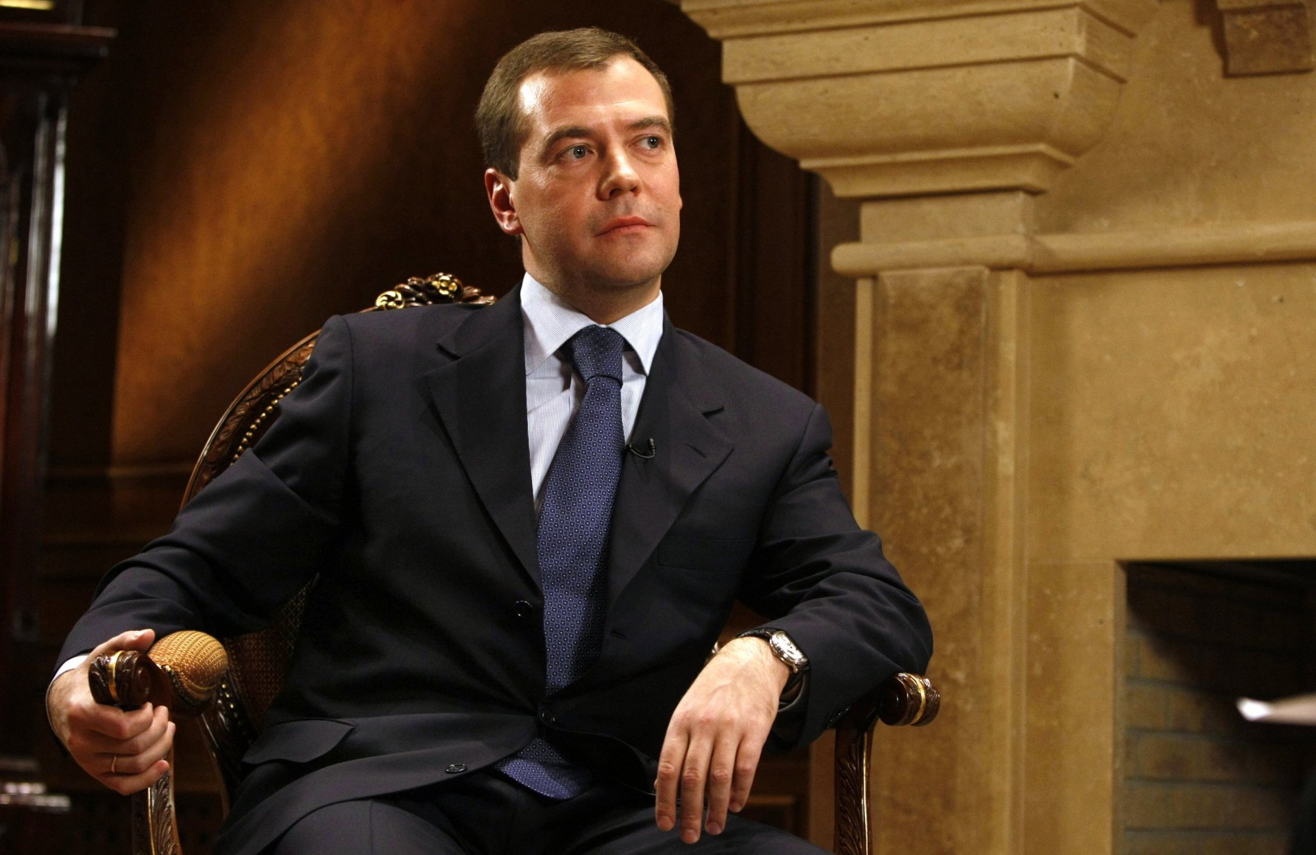 assis dans une chaise président personne importante vue politique portrait russie medvedev dmitri medvedev cravate costume rêverie regard de côté horloge chambre intérieur yeux visage