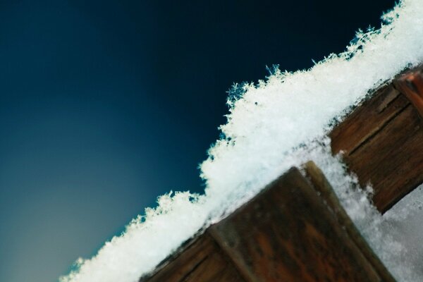 Schneeflocke im Blau des Holzzauns