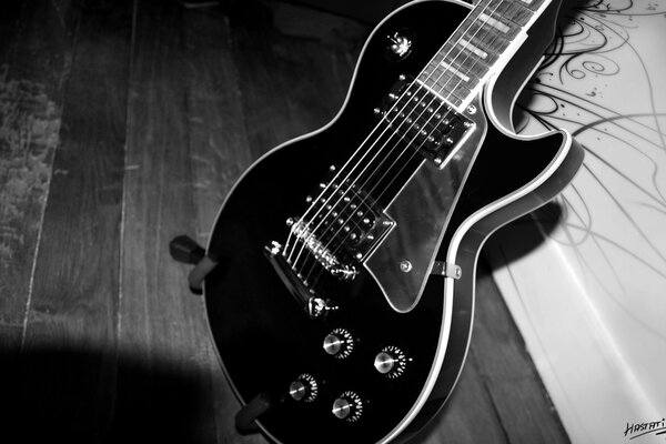 The electric guitar is black. Guitar on a black and white background