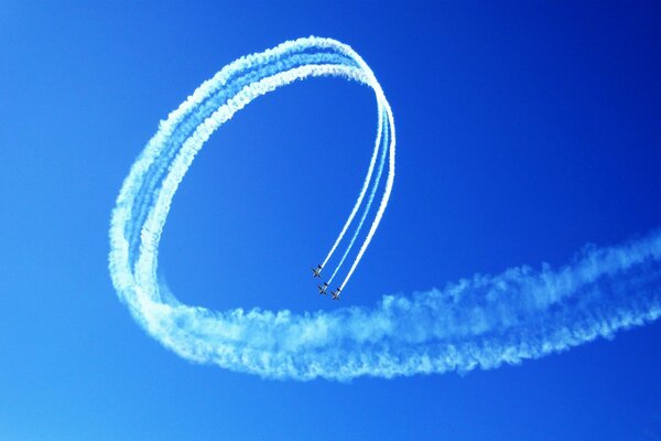 A team of three planes synchronously perform aerobatics