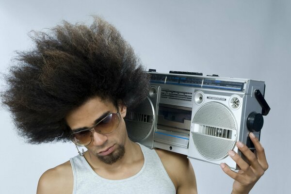 Un gars avec une coiffure luxuriante et un magnétophone