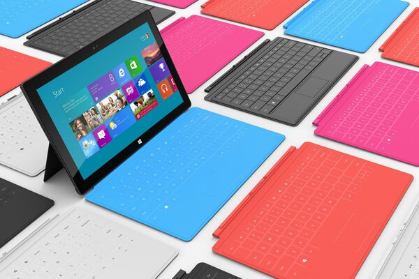 Tablet su un supporto tra tastiere colorate