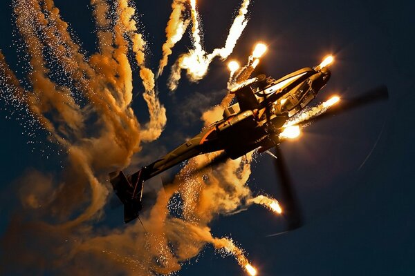 Apache helicopter circling at night in the sky in bright light