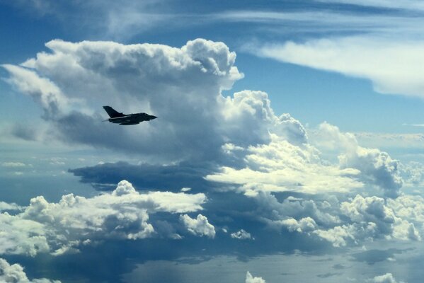 Avion militaire vole dans le ciel parmi les nuages