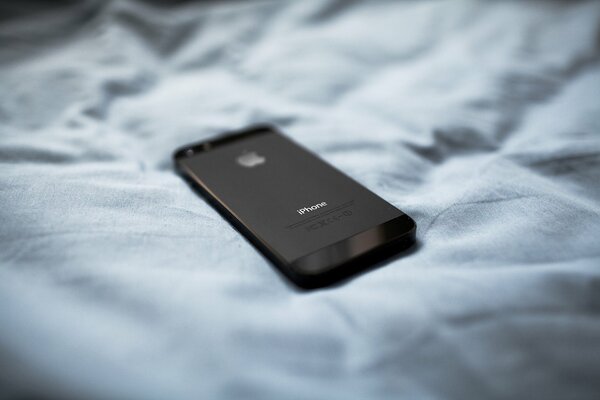 Black iPhone five on soft material