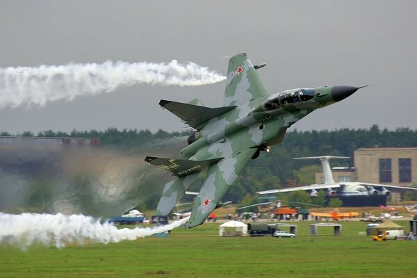 Avión gris realiza una figura acrobática en el despegue