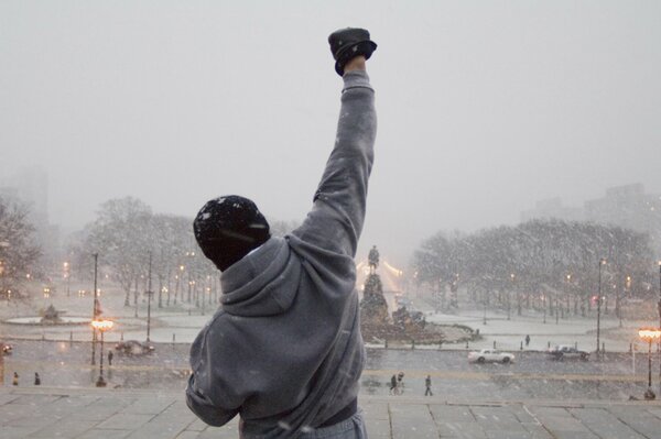 A man with his back in a winter city