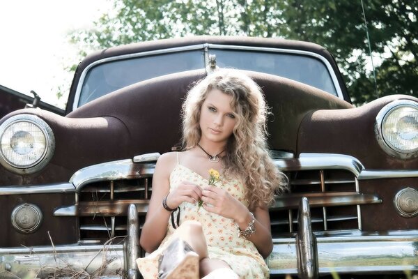 Blonde with curly hair on the background of a car