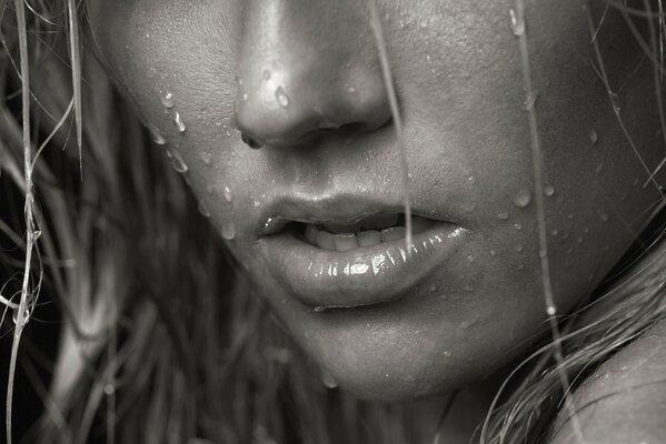 Sensual mouth of a girl with raindrops on her face