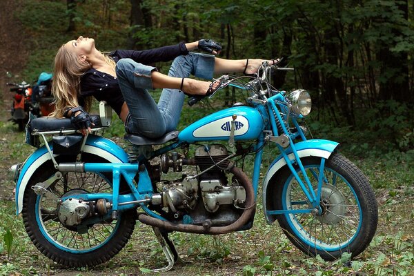 Classic blue motorcycle and a girl sitting on it