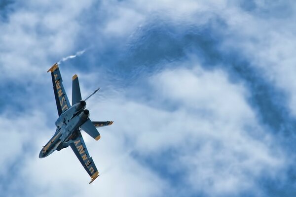 Blaues Kampfflugzeug am Himmel mit Wolken