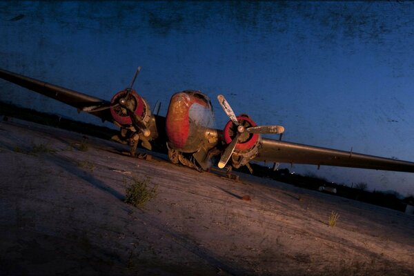 An old rusty plane on the night airstrip