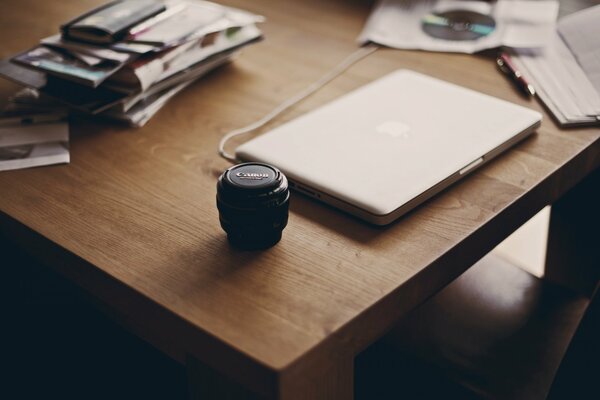 Laptop, lens and documents on the table