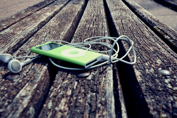 The headphones are lying on a wooden bench