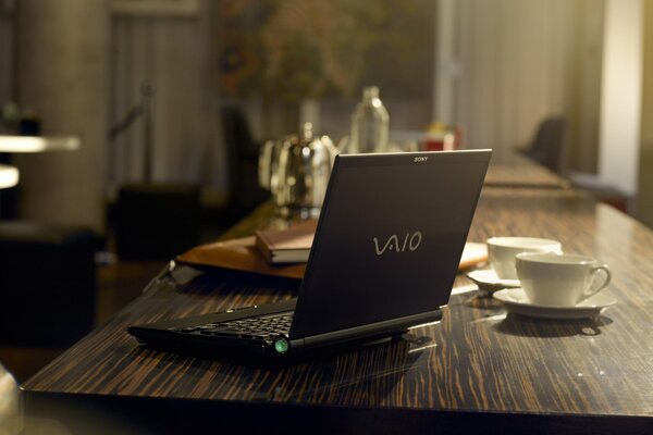 Ordinateur portable noir sur un bureau sombre