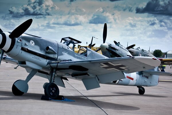 Messerschmit aircraft at the airfield against a cloudy sky