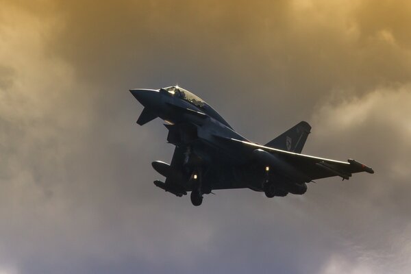 Planning a fighter jet in a cloudy sky