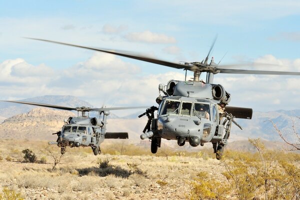 Dos helicópteros grises en el desierto