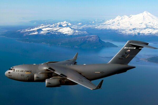 Un avión militar C-17 vuela en medio de las montañas