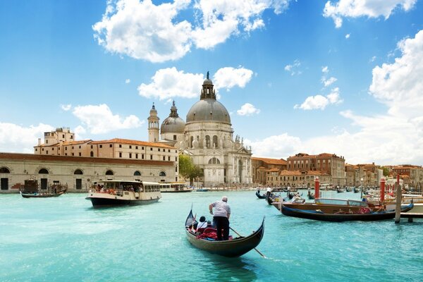 Cathedral and gondolas on the background of blue sky and water