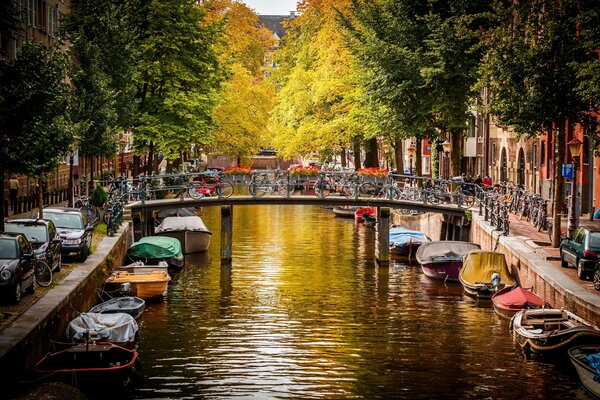 Otoño Amsterdam. Puente calado sobre el agua. Barcos