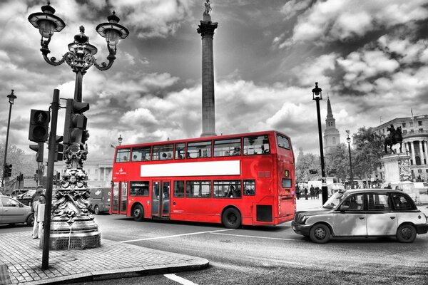 Red bus in a black and white city in England