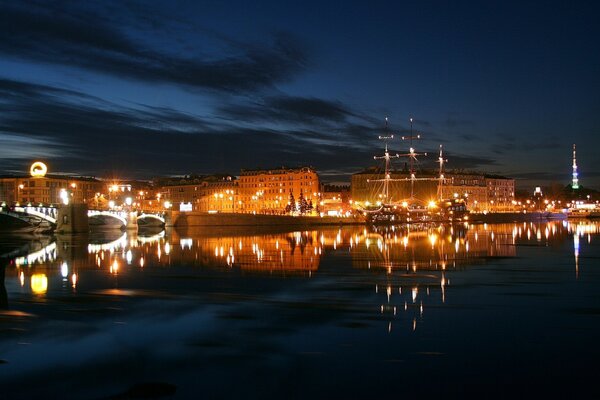 Die Lichter der Nachtstadt spiegeln sich im Fluss wider