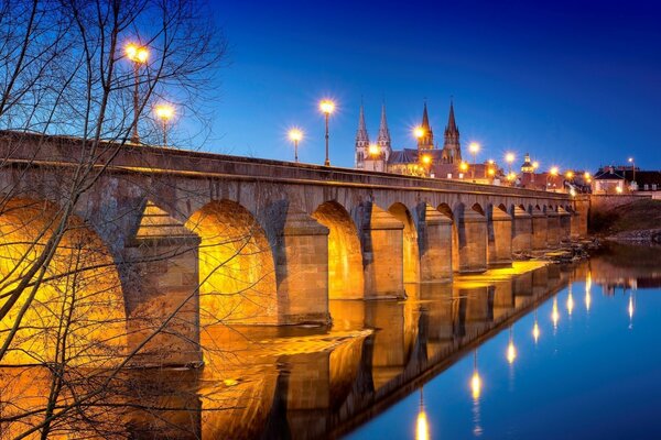 Francia puente nocturno a lo largo del río luces reflectantes