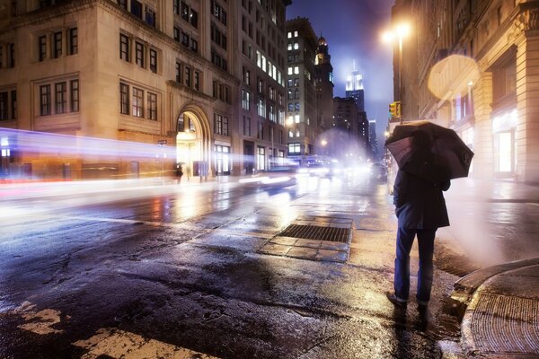 Homme avec parapluie debout dans la rue