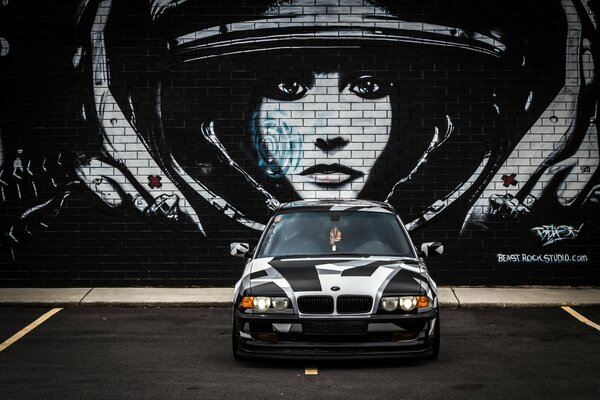 Coche BMW pintura camuflaje Ártico en el fondo de la pared de ladrillo