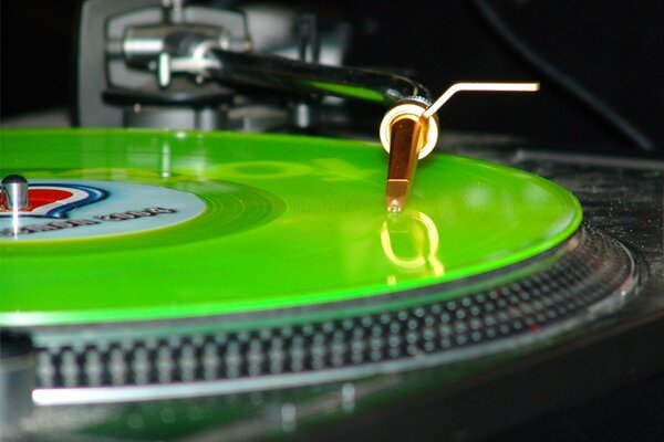 DJ s turntable with green vinyl record