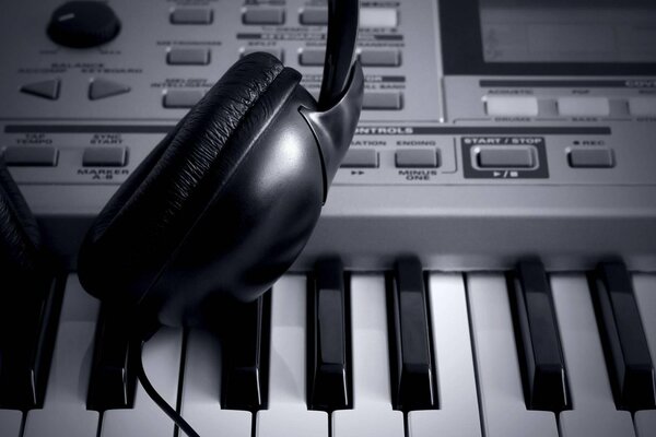 Headphones are on the synthesizer, black and white photo