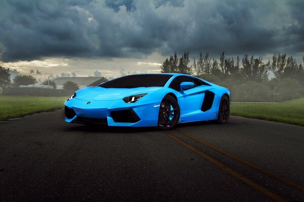 Lamborghini Aventador azul en el fondo de la carretera con nubes